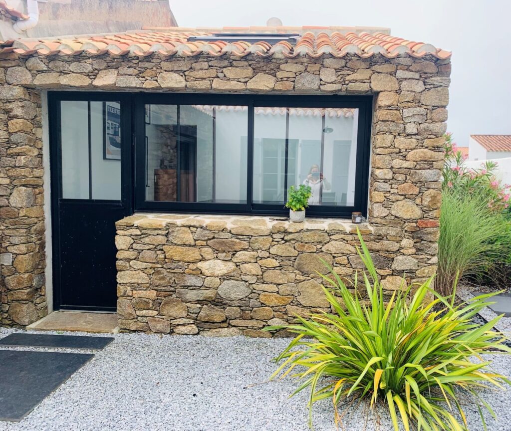 Aménagement d'un patio extérieur cosy et pratique, réalisé sur-mesure par Yeu BTP pour un espace de vie agréable.